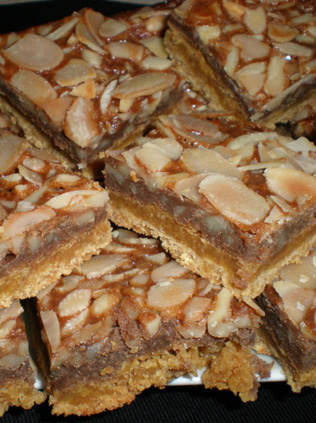 A close up of some bars covered in almonds